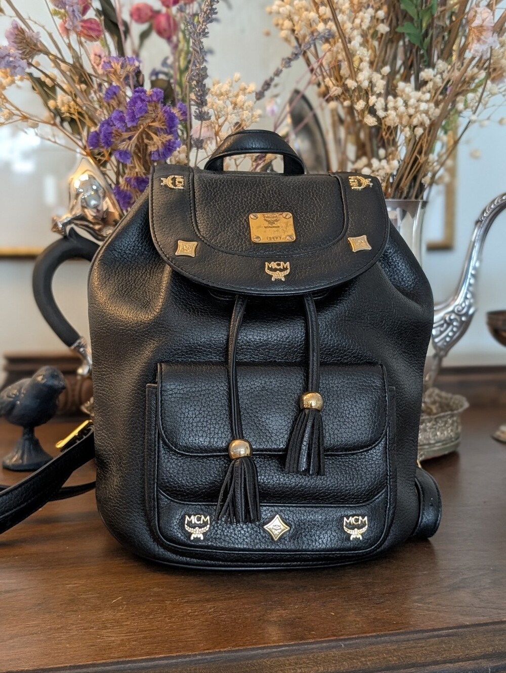 MCM black backpack with golden studded logo motifs and‎ drawstrings.